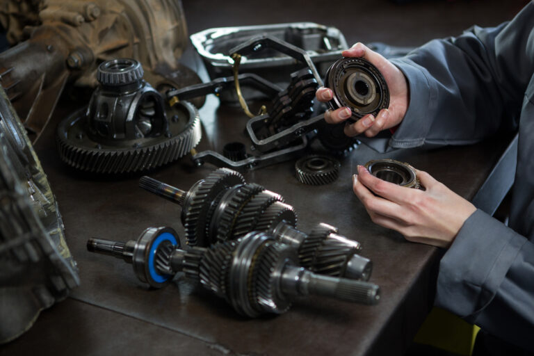 female mechanic holding spare parts car