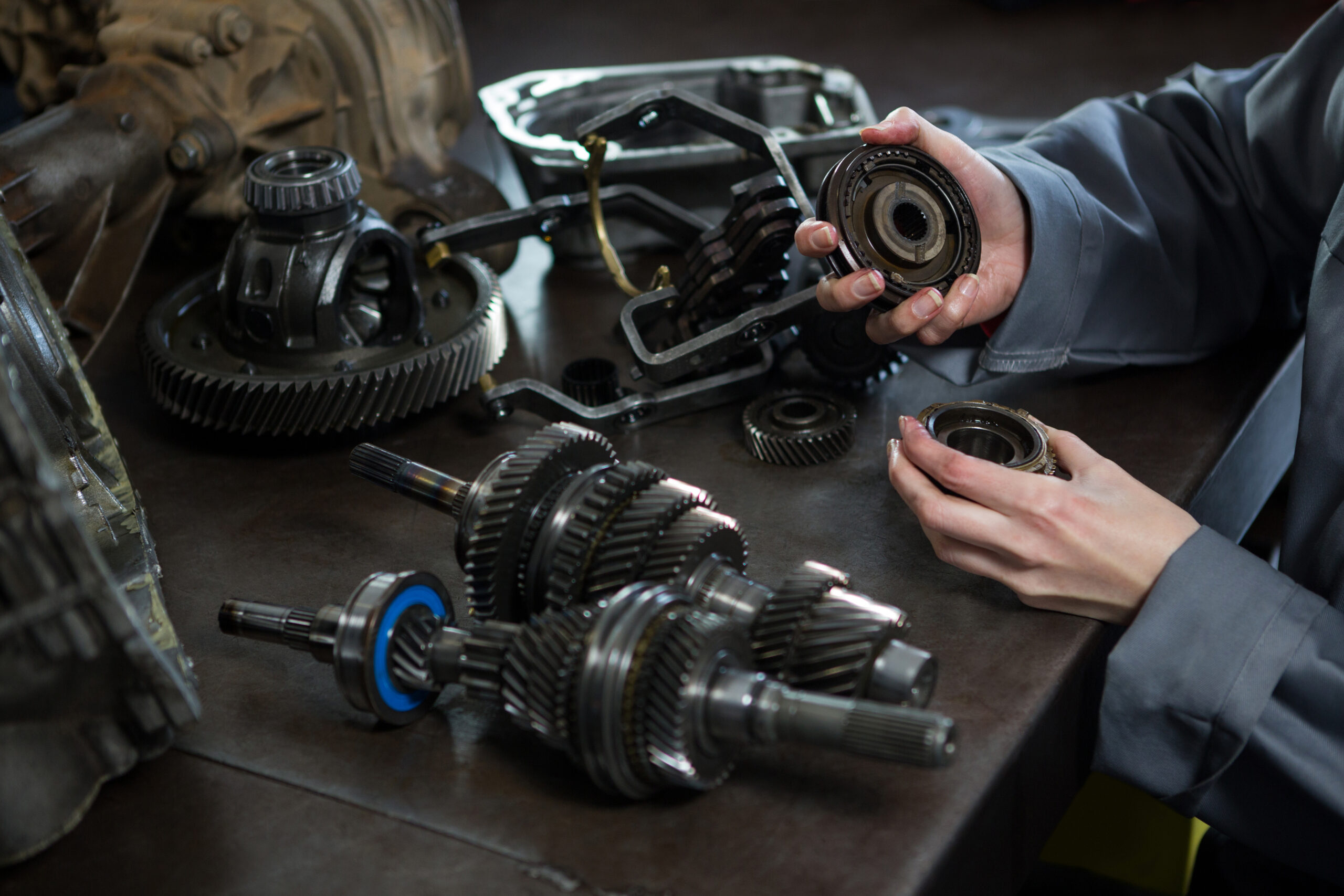 female mechanic holding spare parts car scaled