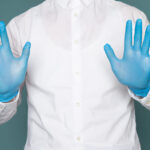 front view young man showing his hands with blue gloves blue space