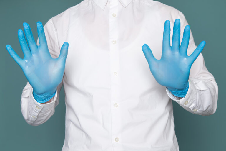 front view young man showing his hands with blue gloves blue space
