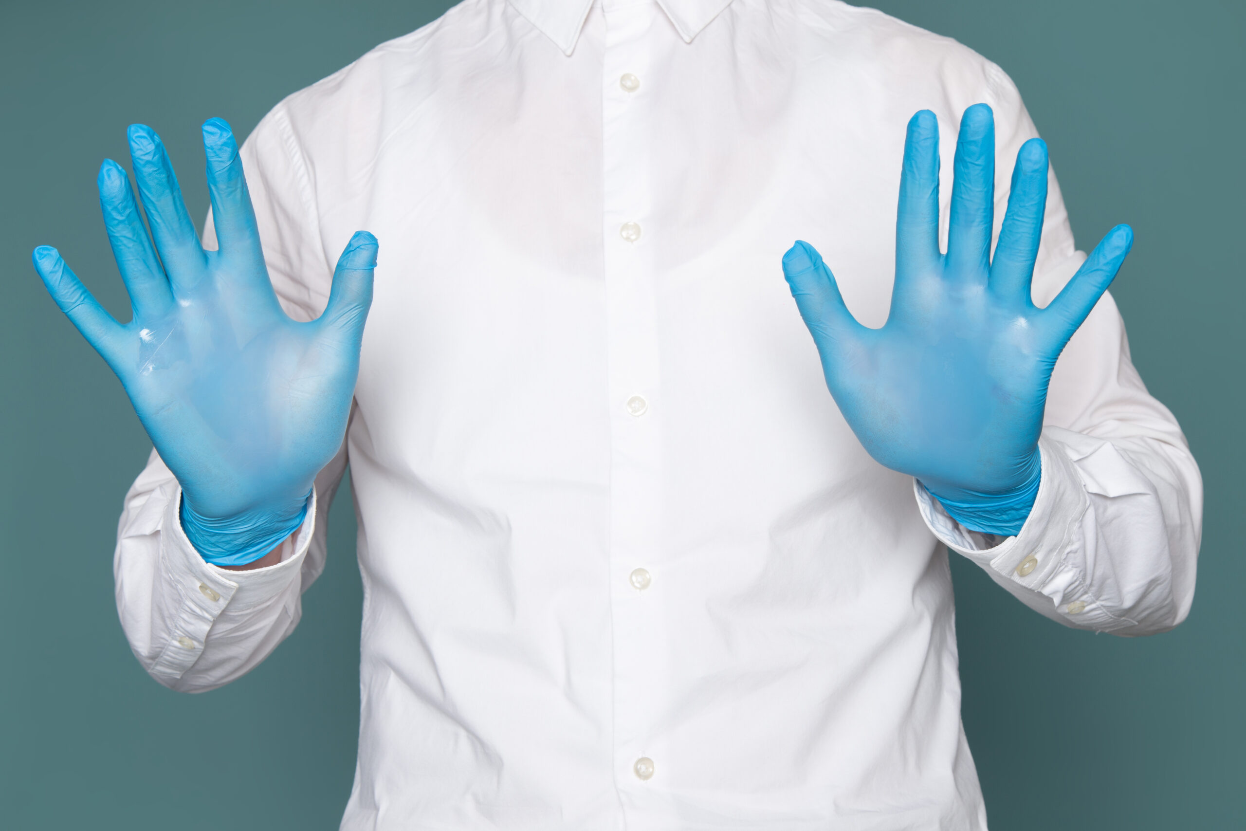 front view young man showing his hands with blue gloves blue space scaled